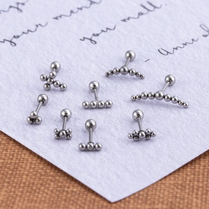 Minimalist stainless steel ball and cross cartilage stud earrings set on white background