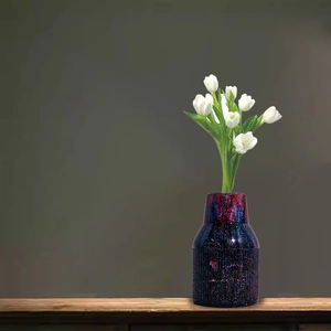 Macro view of starry purple resin vase with vertical stripes and white tulips
