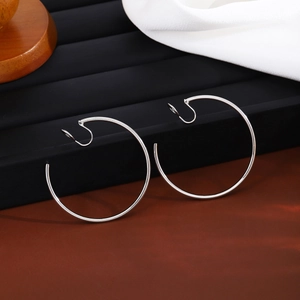 Macro shot of silver metal hoop clip-on earrings on a professional black display