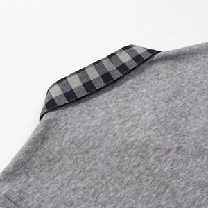 Detail of grey polo collar with classic plaid stitching and fine cotton-blend texture