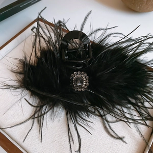 Détail d'une pince à cheveux luxueuse en plumes noires avec un ornement en strass