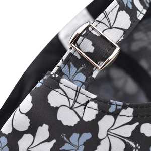 Detail of adjustable metal buckle and tropical floral print on cotton baseball cap