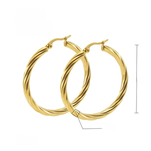 Detail of 40mm gold twisted hoop earrings in 18K vacuum plated stainless steel