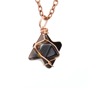 Detail of handcrafted wire-wrapped dark crystal pendant with antique copper wire on O-chain
