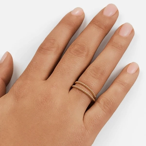 Detailed view of double layered gold beaded ring worn on a finger for style