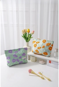 Detail of floral canvas makeup bags with zippers and embroidered textures on display