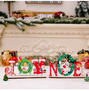 Dettaglio di decorazioni natalizie JOY e NOEL in legno con motivi di renne e Babbo Natale