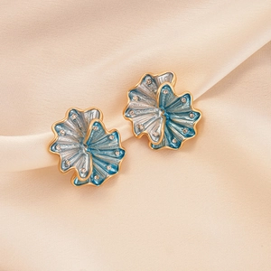 Elegant gold-rimmed blue flower stud earrings with diamonds on silk fabric