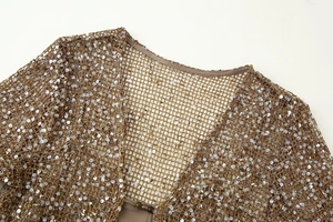 Gros plan détaillé du tissu en maille à paillettes dorées avec texture crochetée