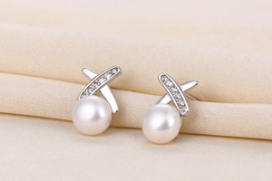 Detailed macro view of S925 silver cross-line pearl earrings with micro-inlaid zircons