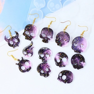 Skull earring silicone molds with resin pendants in purple and black glitter