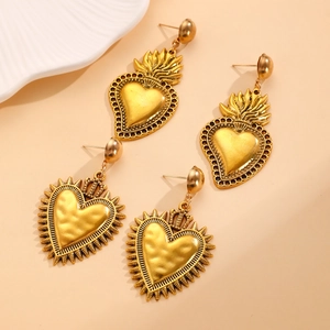 Detail of vintage gold earrings featuring sacred heart and crowned heart designs