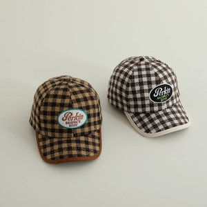 Detailed view of plaid wool baseball caps with oval embroidered patches and piping edge