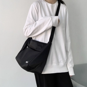 Modern black canvas messenger bag shown on model for daily commuting style