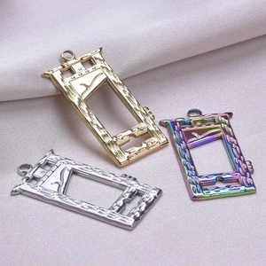 Detailed view of guillotine pendants in gold, silver, and rainbow 18k plated finishes