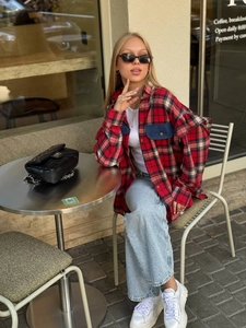 Chemise à carreaux rouge et noir portée avec un jean bleu clair et un sac matelassé