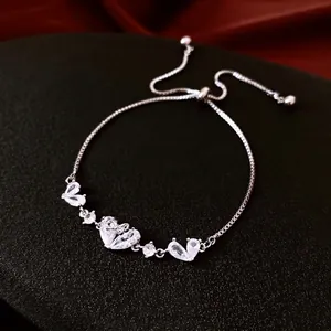 Adjustable silver bracelet with heart and teardrop zircon crystals on black textured mat