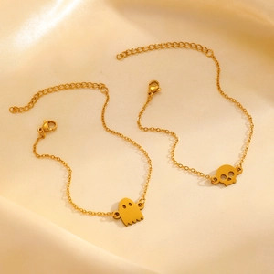 Golden stainless steel jewelry set featuring hollow ghost and skull pendants on satin