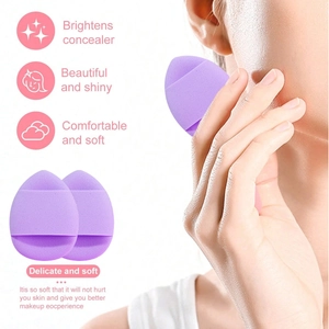 Detailed view of soft purple makeup puff and a model applying concealer on her face