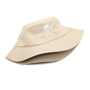Gros plan d'un chapeau bob beige en coton avec broderie de crâne et os blancs