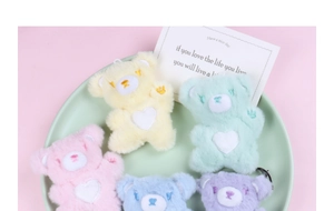 Close-up of five colorful plush heart bears in yellow pink blue and purple colors