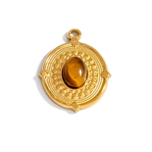 Detail of a vintage gold pendant featuring an oval brown tiger eye stone and sunburst engraving