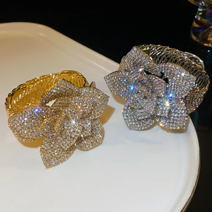 Detailed view of adjustable gold and silver floral bracelets with sparkling crystals