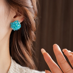 Close-up of model wearing blue seed bead cluster earrings in a vintage round design