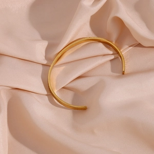 Detailed macro view of 18K gold-plated hammered texture on an open cuff bracelet