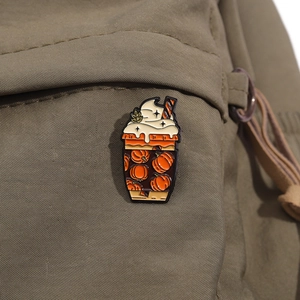 Vue détaillée d'une broche en émail pumpkin spice latte épinglée sur un sac en toile