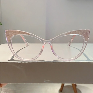 Detail of cat-eye glasses frame featuring pink glitter accents and transparent pink plastic