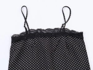 Detail of black polka dot camisole featuring delicate lace trim and adjustable thin straps