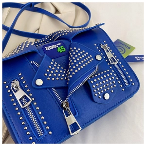 Detail of blue biker jacket shaped handbag with silver studs and embroidered touring patch