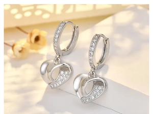 Detailed close-up of silver heart drop earrings with micro-set cubic zirconia crystals