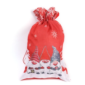 Detail of red and white burlap Christmas gift bag with gnome prints and drawstring