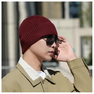 Détail d'un bonnet en tricot bordeaux avec texture côtelée porté en extérieur en hiver