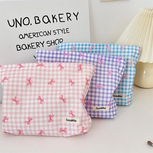 Dettaglio delle pochette trucco in cotone floreale con motivi a fiocco e cerniera