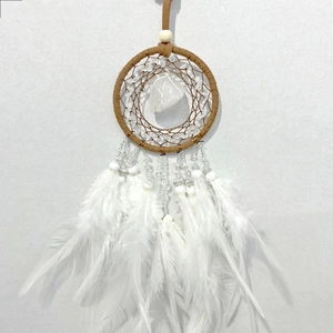 Detail of dream catcher with brown hand-woven net, crystal stone and white feathers