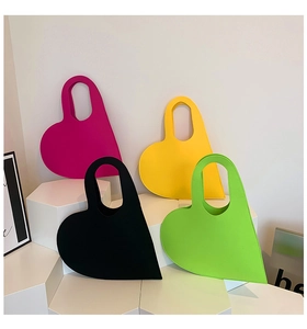 Detailed display of heart-shaped felt handbags in pink, yellow, black and green colors