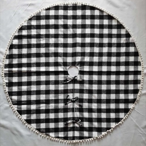 Klassische schwarz-weiße Weihnachtsbaumdecke mit weißen Pompons und Schleifenverschluss