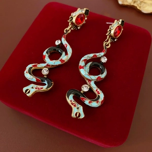 Macro shot of vintage snake earrings with blue enamel and sparkling rhinestones in a gift box