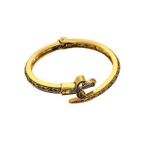 Detailansicht eines goldenen Schwert-Armbands mit aufwendigen schwarzen Vintage-Gravuren