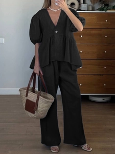 Close-up of black V-neck puff sleeve top and wide-leg linen pants loungewear set