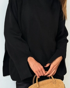 Detailed close-up of a black knit sweater featuring unique split cuff design details