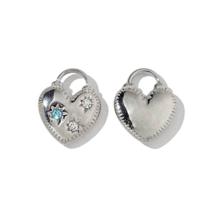 Detailed macro view of heart-shaped stainless steel charms with blue star-set gemstones
