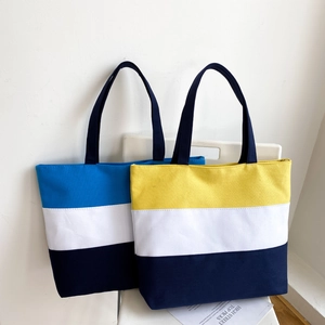 Detailed side-by-side display of tricolor patchwork canvas tote bags on a white chair