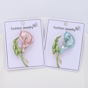 Detail of enamel calla lily brooches with sparkling rhinestones on jewelry card