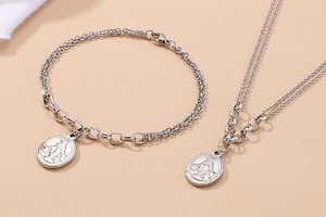 Detail of silver double-layered stainless steel necklace and bracelet with religious pendant