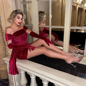 Détail d'une robe de soirée en velours rouge avec gants assortis et taille ajustée