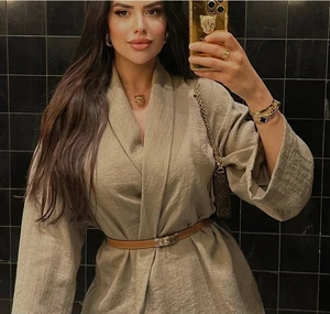 Detail of beige jacquard robe dress with long sleeves and slim brown leather belt